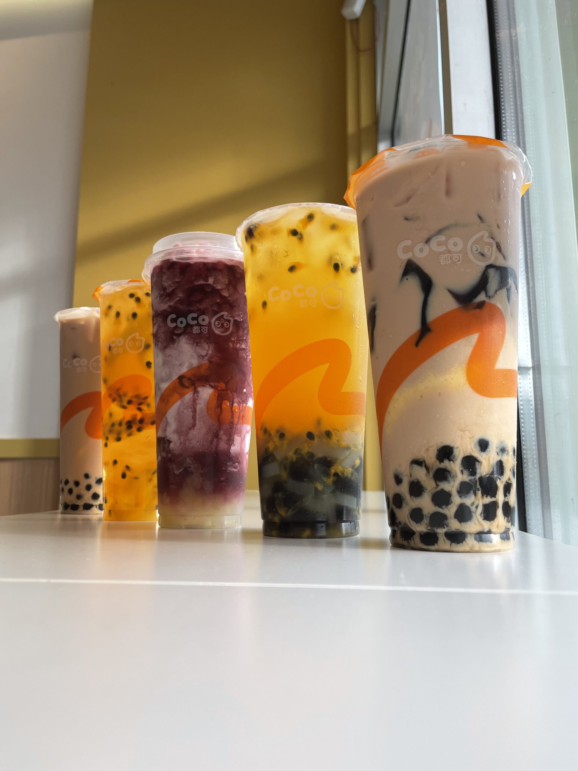 5 Different Drinks lined up, Milk Tea, Bubble Gaga, Grape Smoothie, Bubble Gaga, and Milk Tea