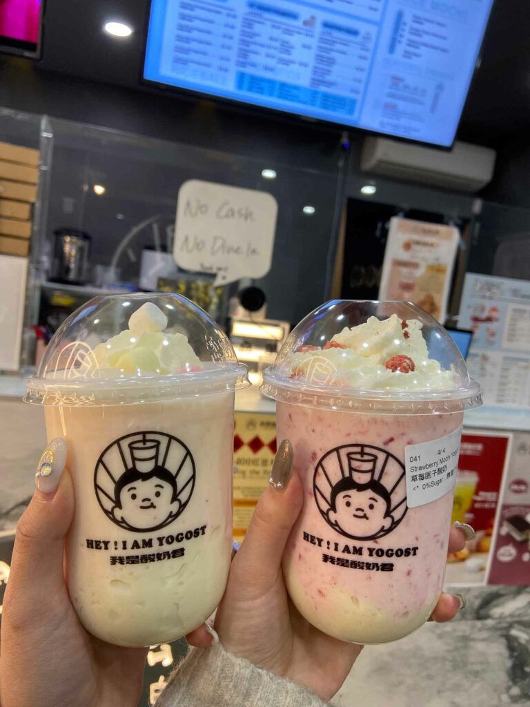 Holding two Yogost Drinks, Left is Banana, Right is Strawberry